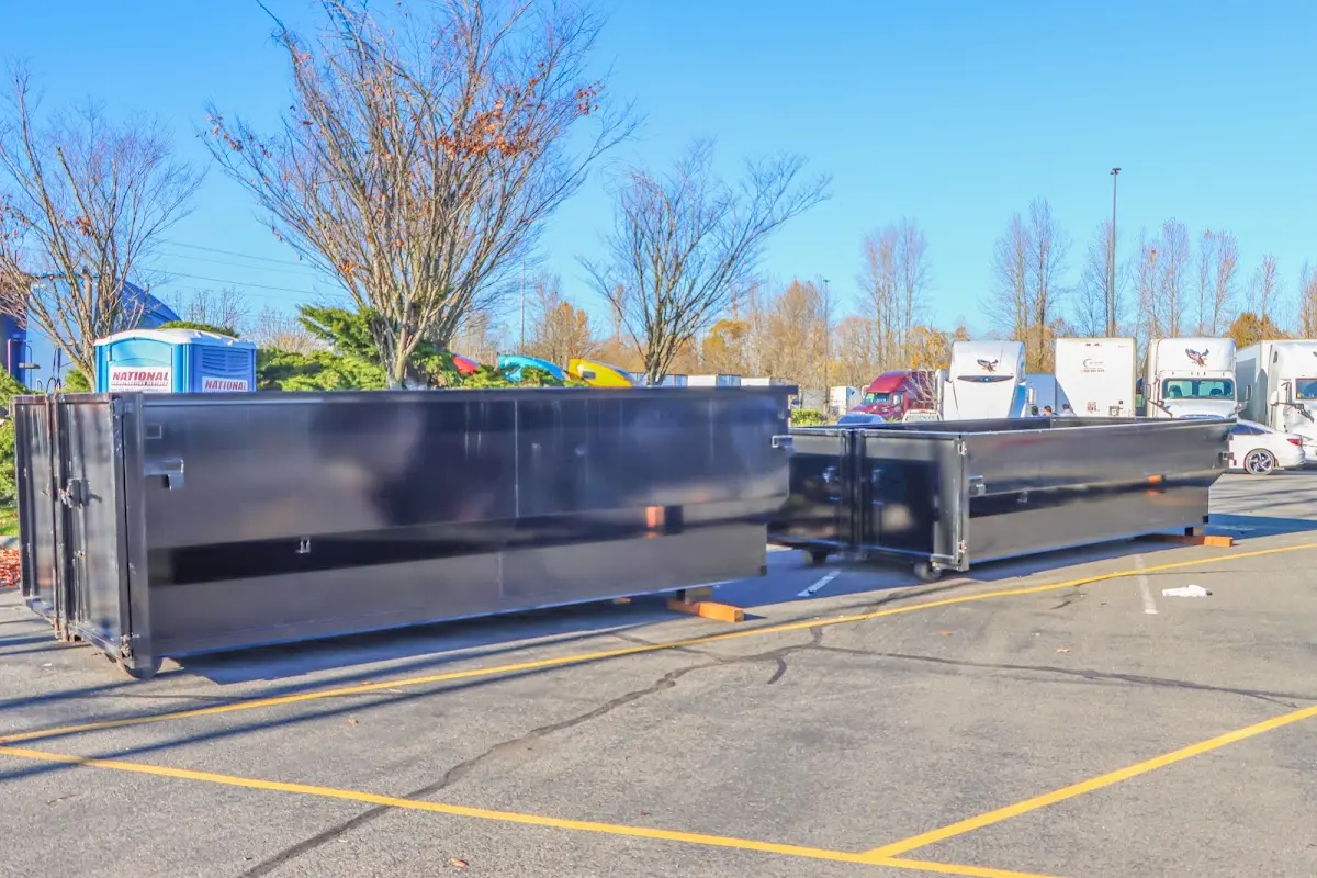 Professional dumpster rental service with roll-off container on residential driveway in East Hempfield
